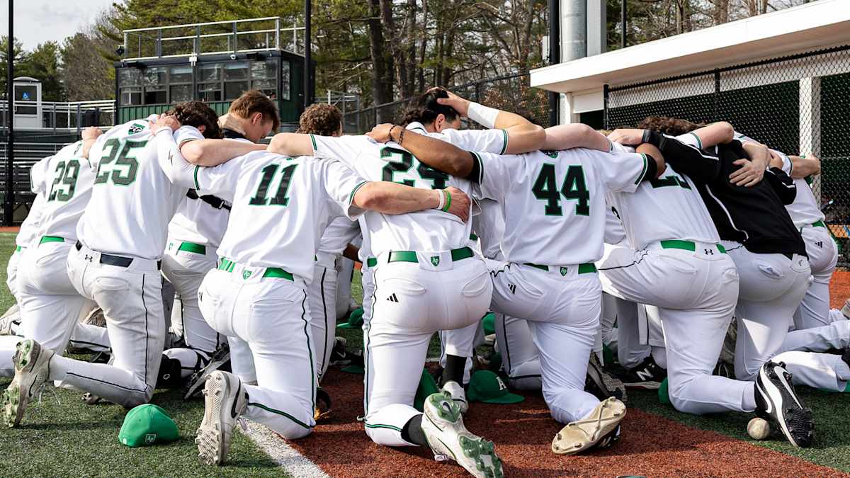 Austin Prep Varsity Baseball team praying together at Regis Paul Little Memorial Field before a home game
