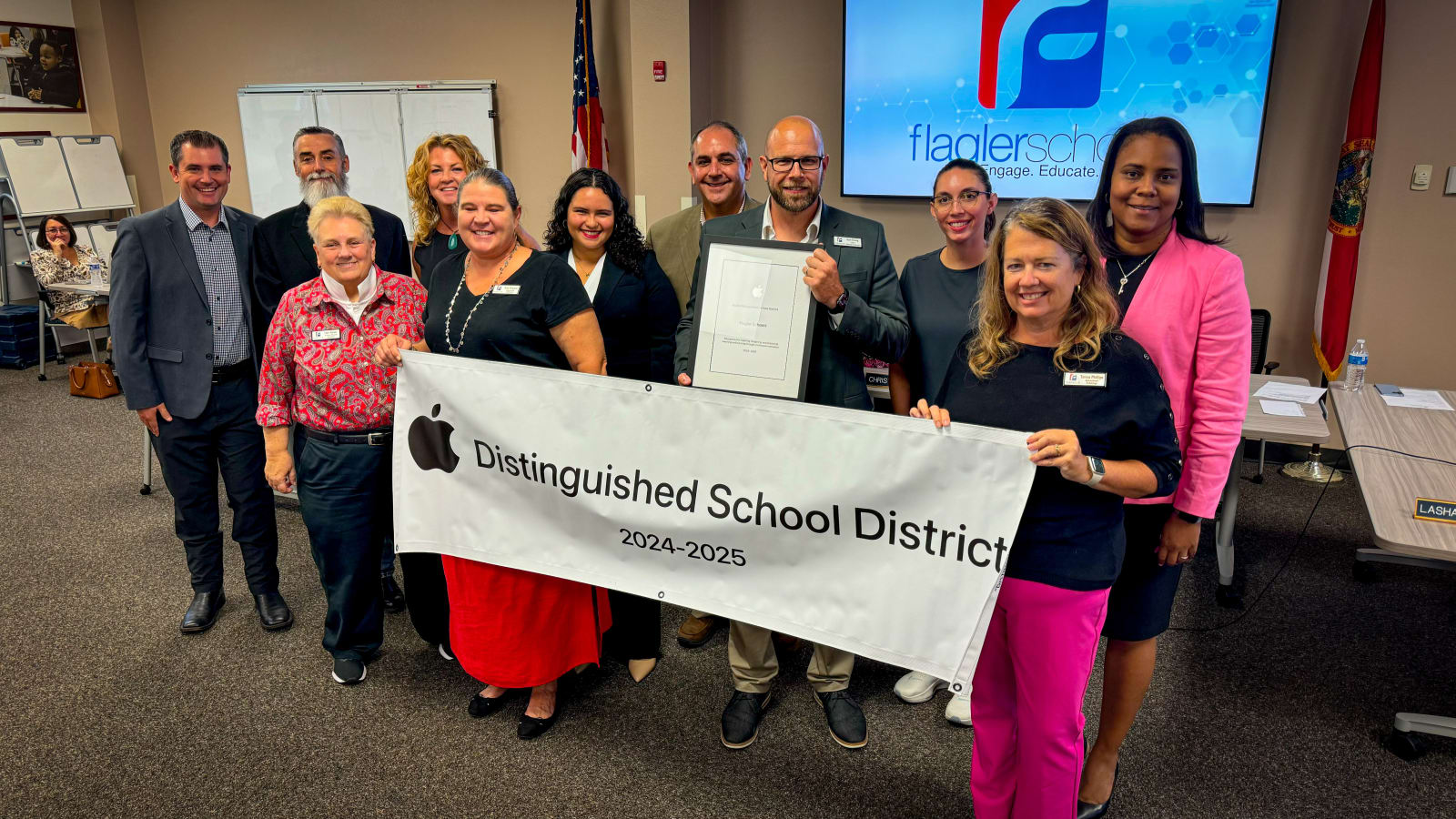 Flagler Administration holding apple distinguished district banner
