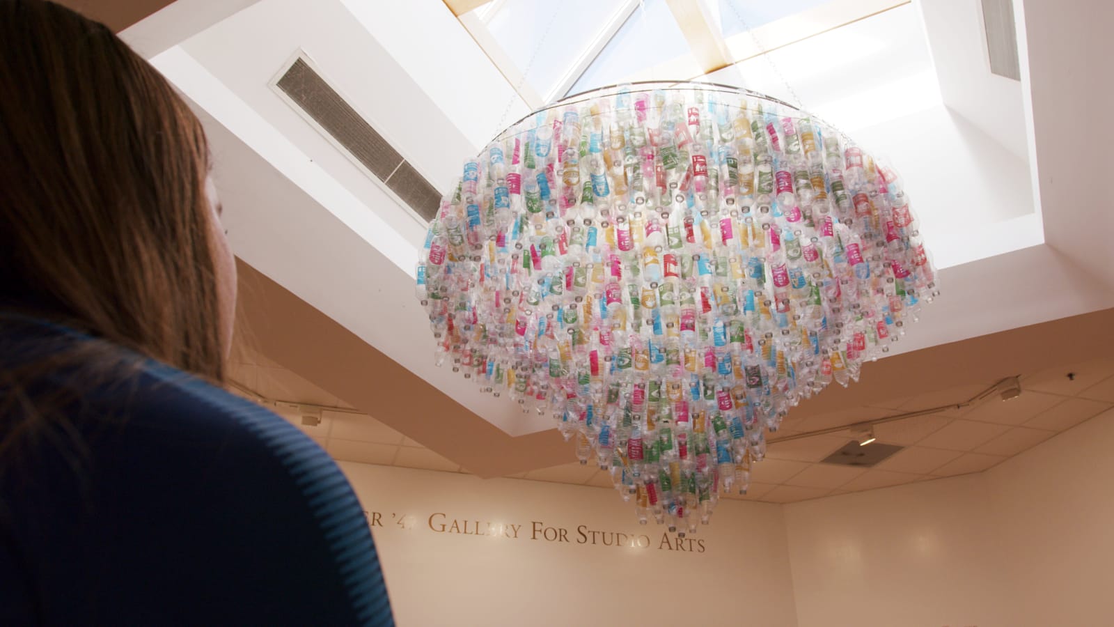 A water bottle chandelier hangs from a skylight