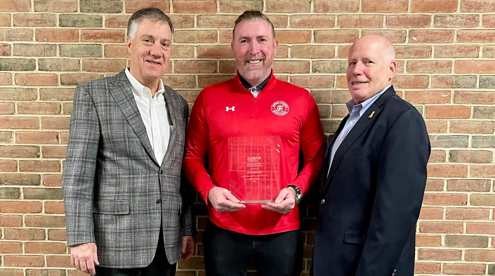 Head of School Donald Austin, Director of Operations Brian Stephenson holding a plaque and Director of Business and Finance Sam Goldfischer