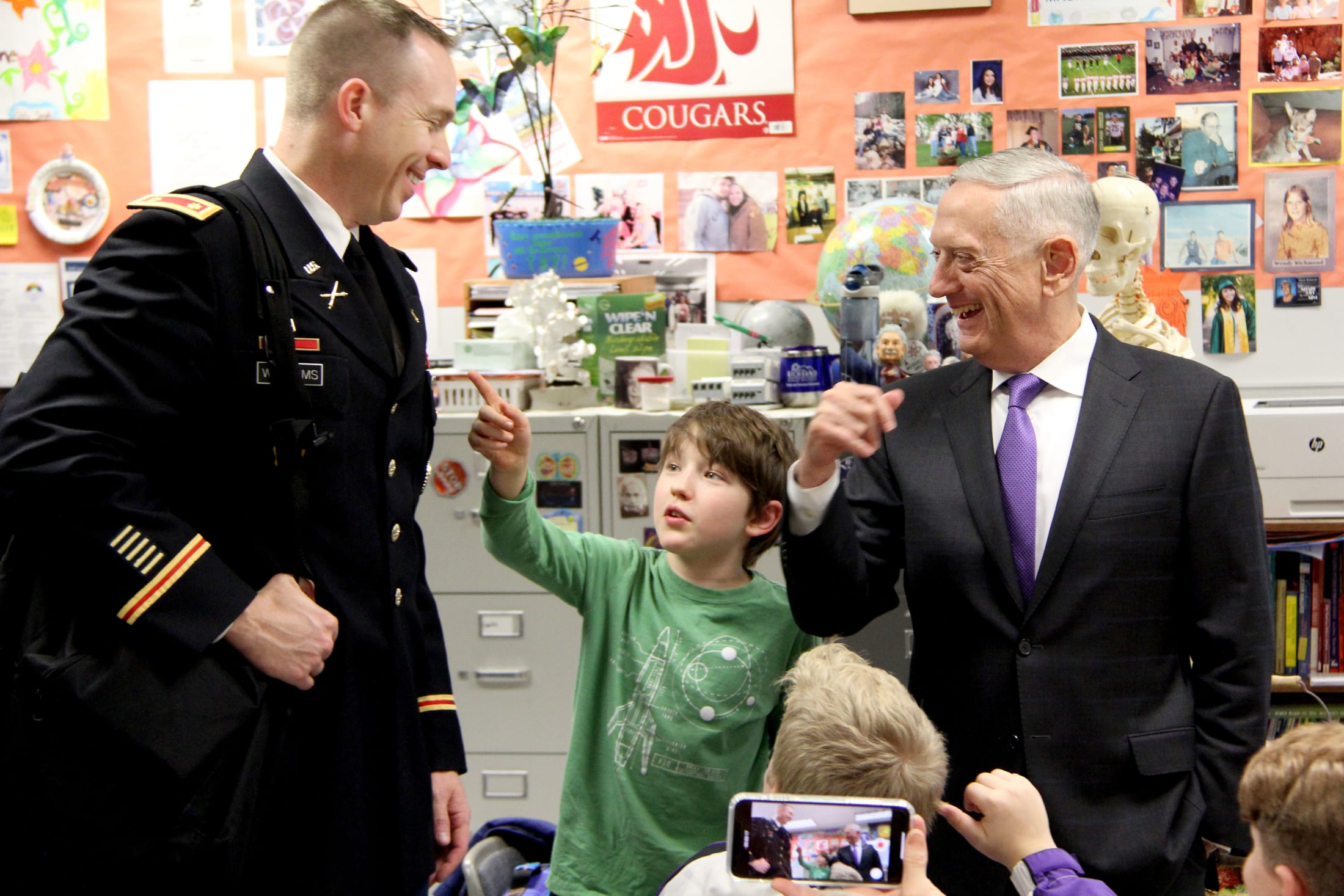 A student interacts with Defense Secretary Jim Mattis and his aide during a visit to Chief Joseph Middle School.