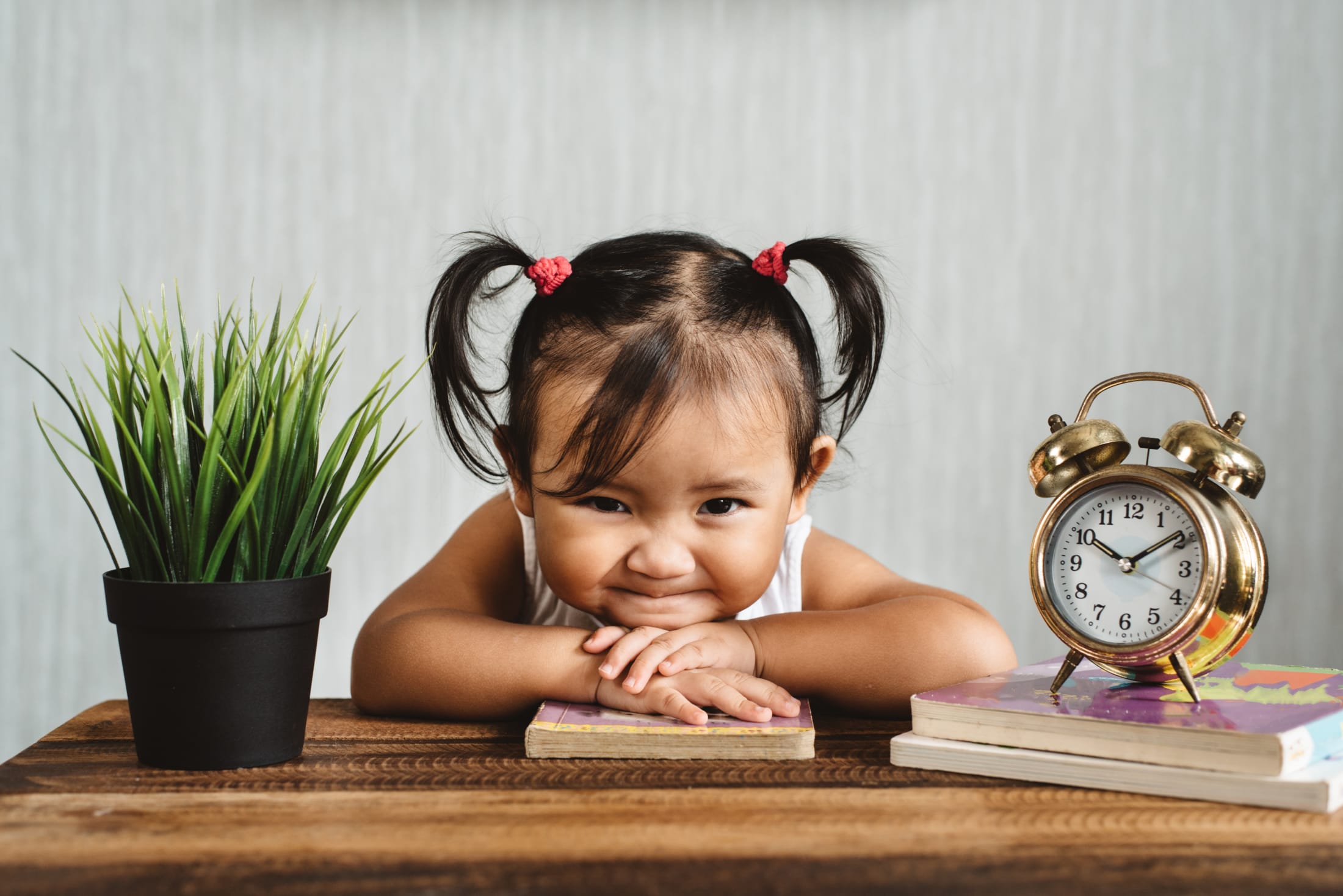 girl smiling next to clock
