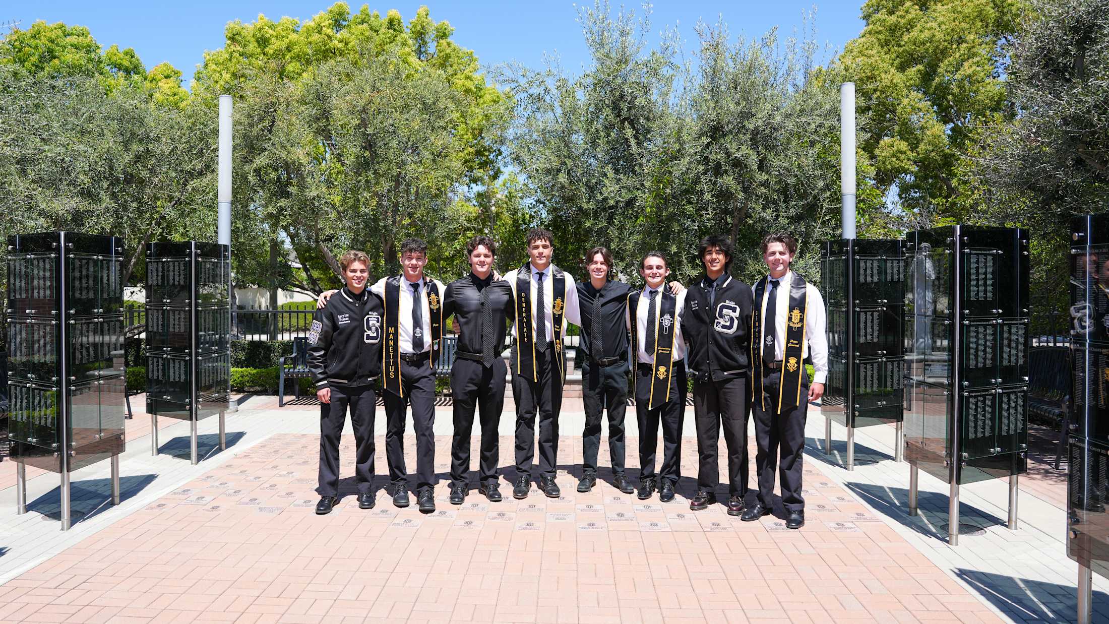 Servite student leaders standing in a campus memorial area