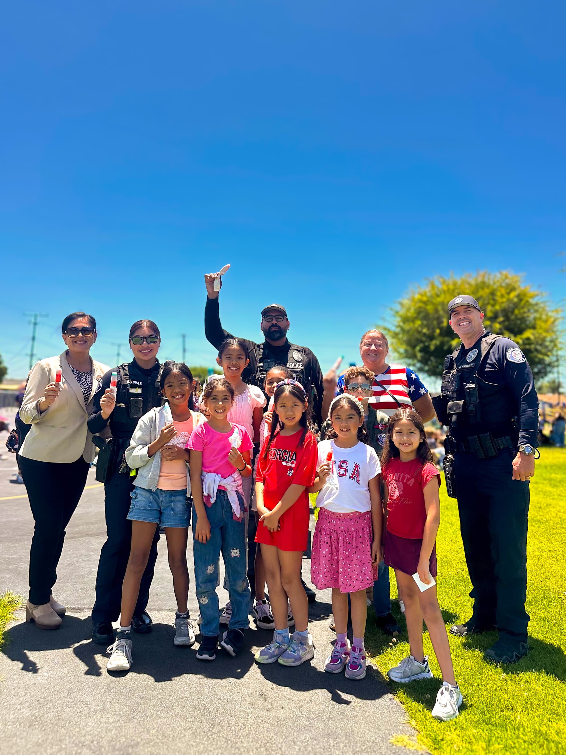 WSD students, admin, and staff standing outside with Police for the pops with Cops event.