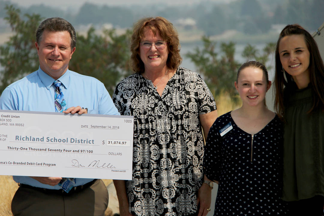 District leaders and students accept $31,000 donation from Gesa Credit Union from use of school-branded debit cards.