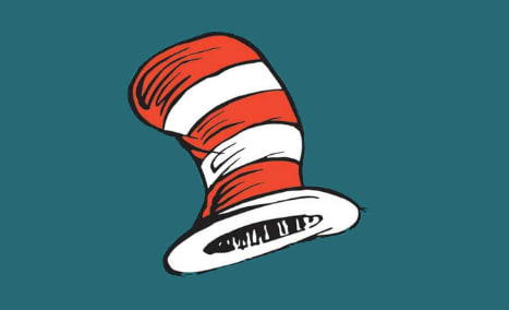 A vibrant, striped hat with a distinctive conical shape stands out against a deep teal background.