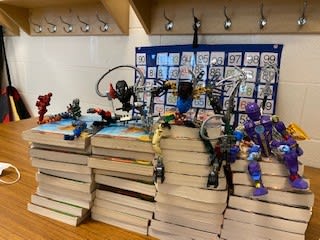 Piles of books with toys on top of them