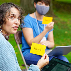 Image of workshop participant holding a card that says PEACE.