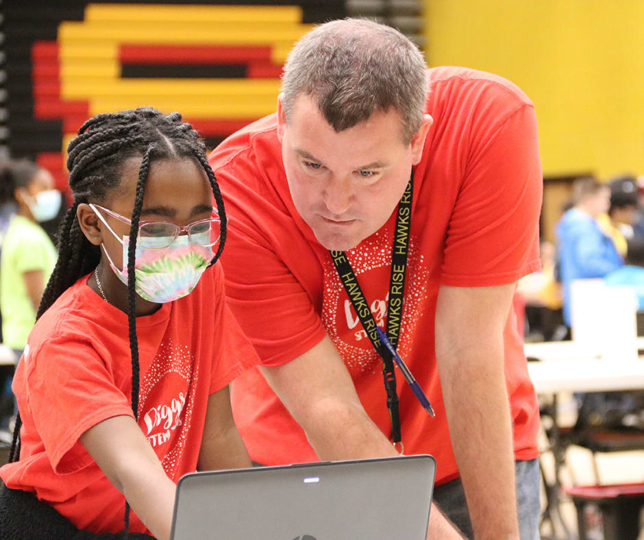 Michael Johnson, a science teacher at William A. Diggs Elementary School, is a co-sponsor of the school’s Mathematics, Engineering, Science Achievement (MESA) team. Johnson and Diggs student, Bryelle Paxton, go over a project at a recent regional MESA competition. 