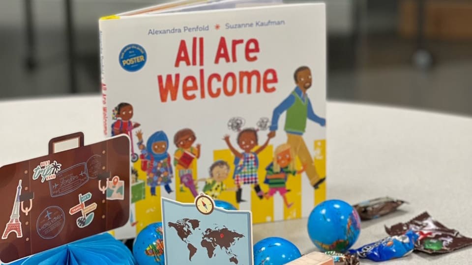 Table decorations at Ruby Bridges Elementary include a book titled ''All Are Welcome,'' small globes, and a small map of the world
