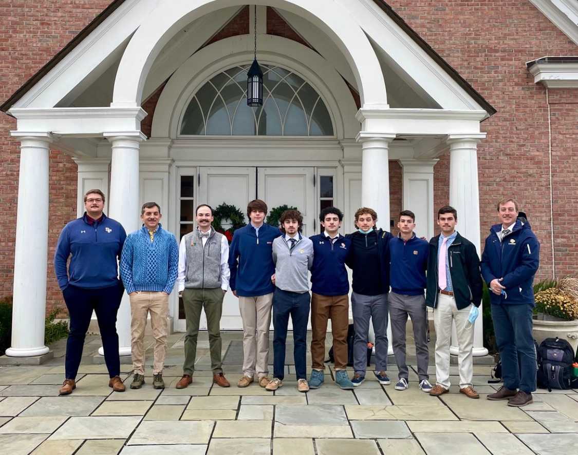 Students and teachers standing in front of church smiling