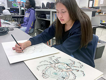 Maxwell student drawing in art class