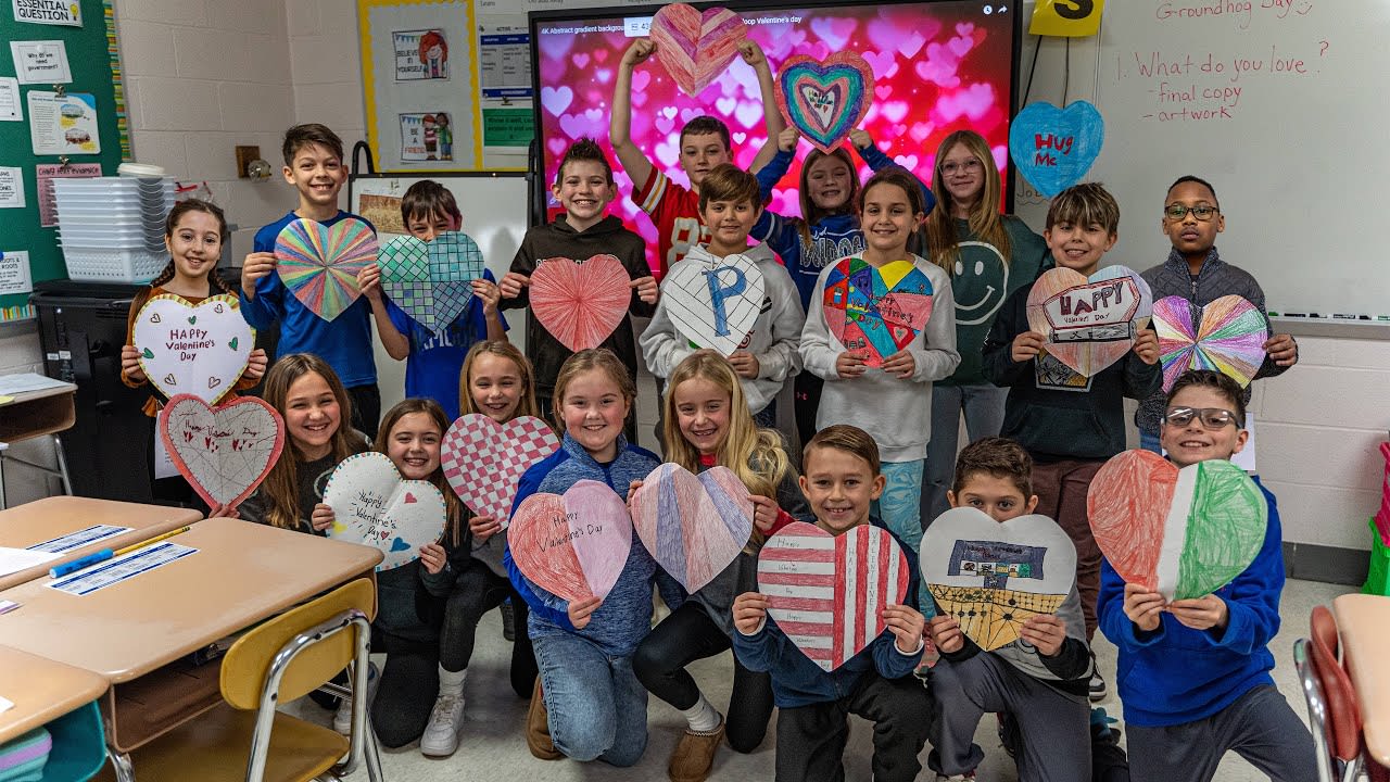 4th grade students holding heart decorations