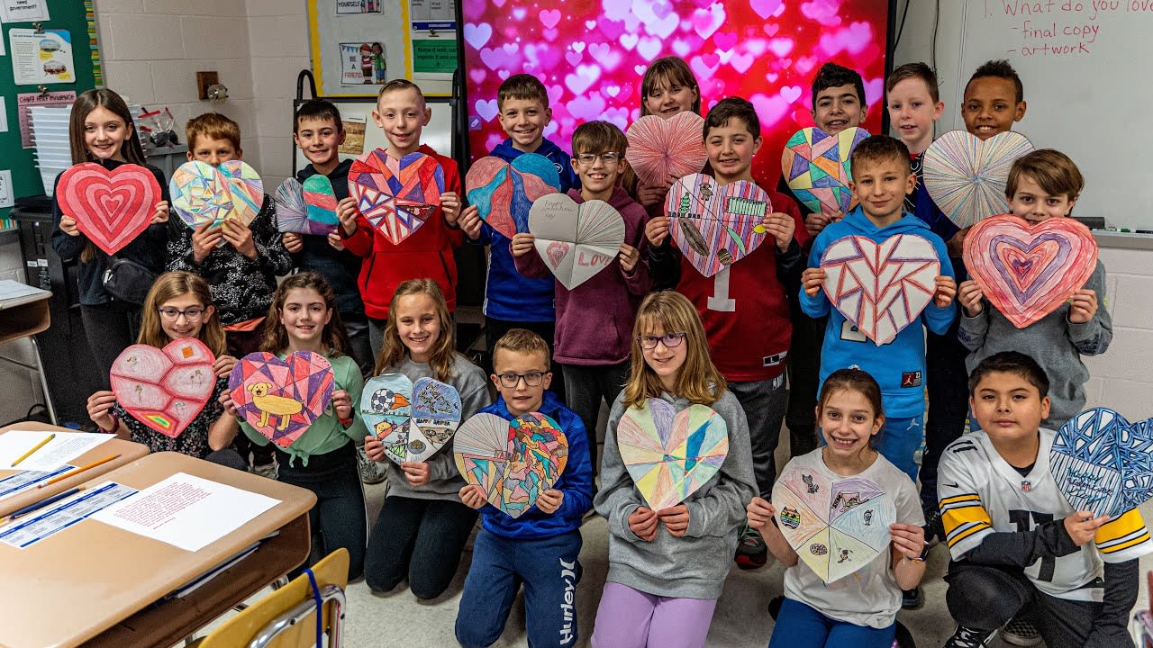 4th grade students holding heart decorations
