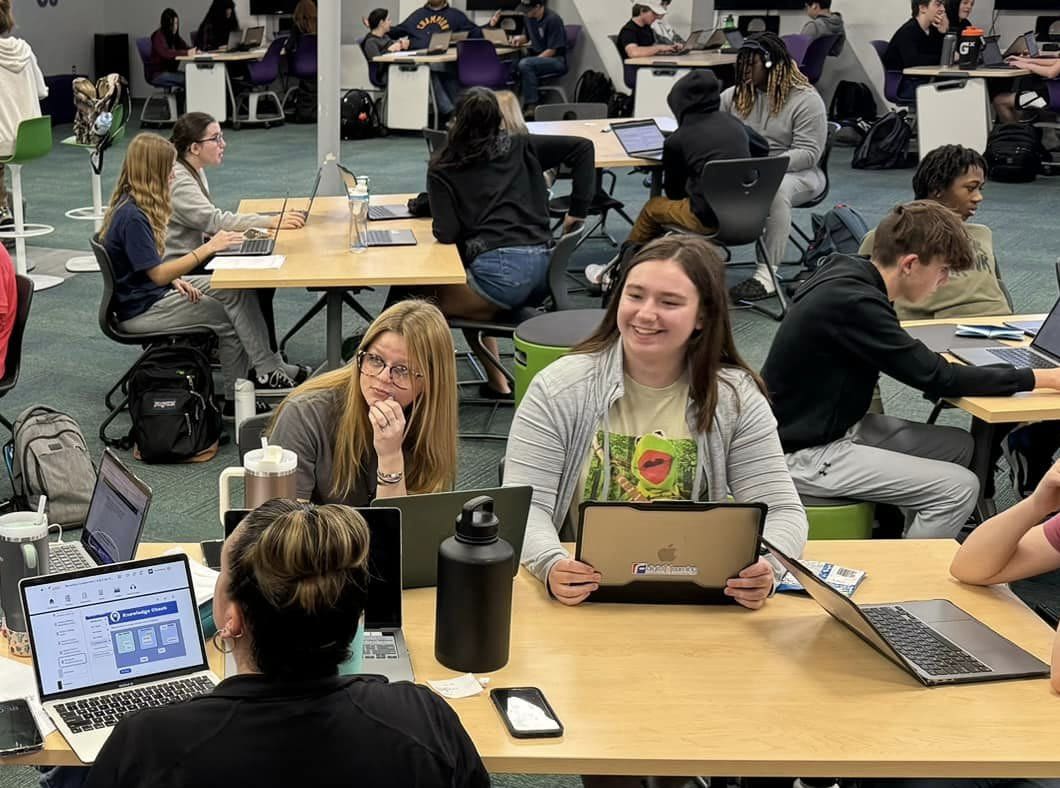 A group of high school students with laptops at a table
