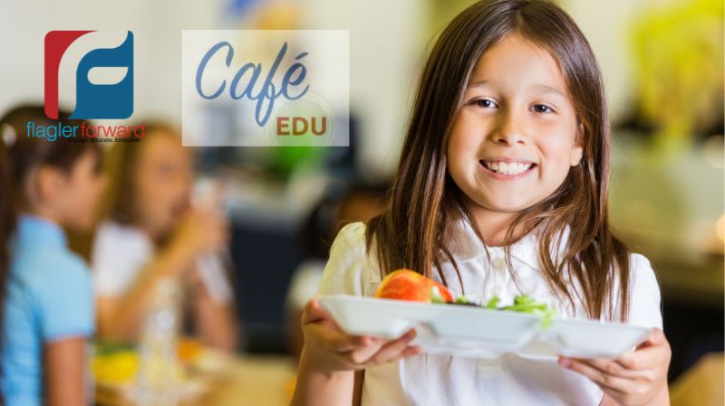 Little girl in a lunchroom holding a food tray and smiling