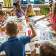 Elementary students in art class painting at a table