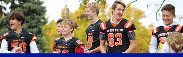 A team of young men in football uniforms poses together, embodying the energy and unity of their athletic pursuit.