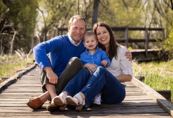 family sitting on a bridge