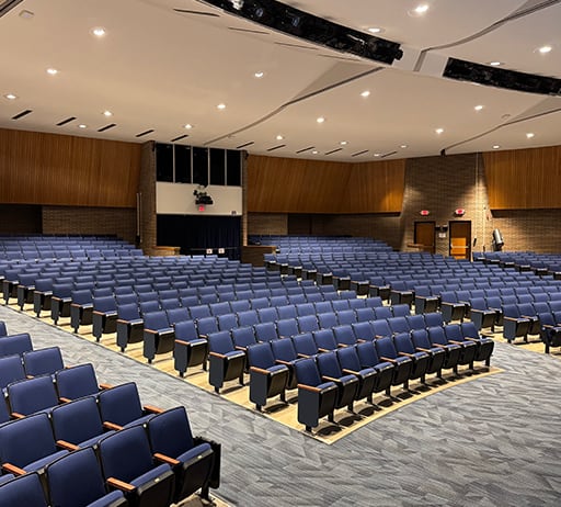 Rows of blue seats inside the Copley High School auditorium
