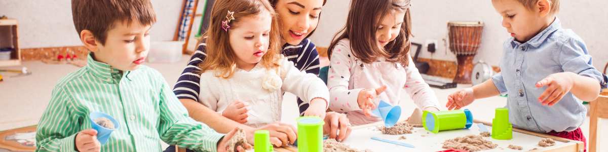 young children playing with clay at a low table