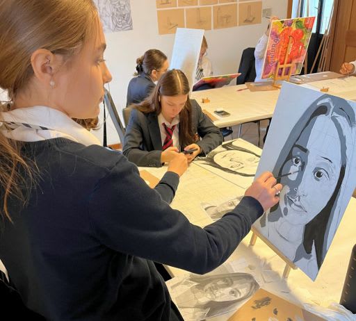 A CCI student painting a portrait in art class