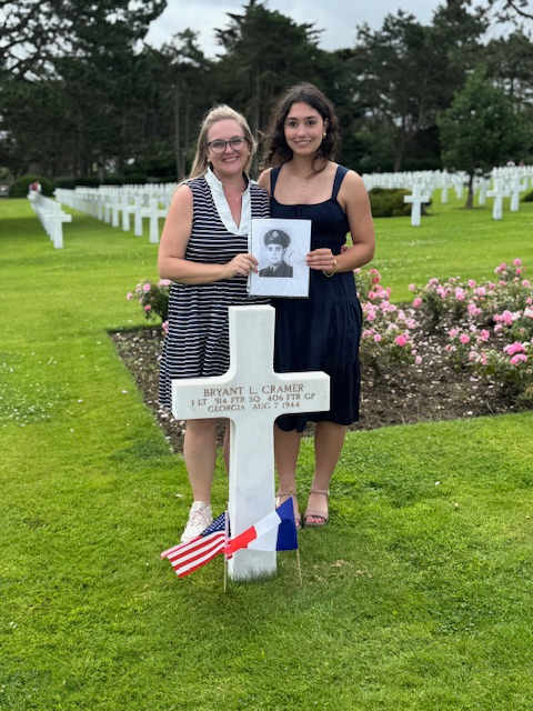 Student and teacher stand graveside at Normandy.