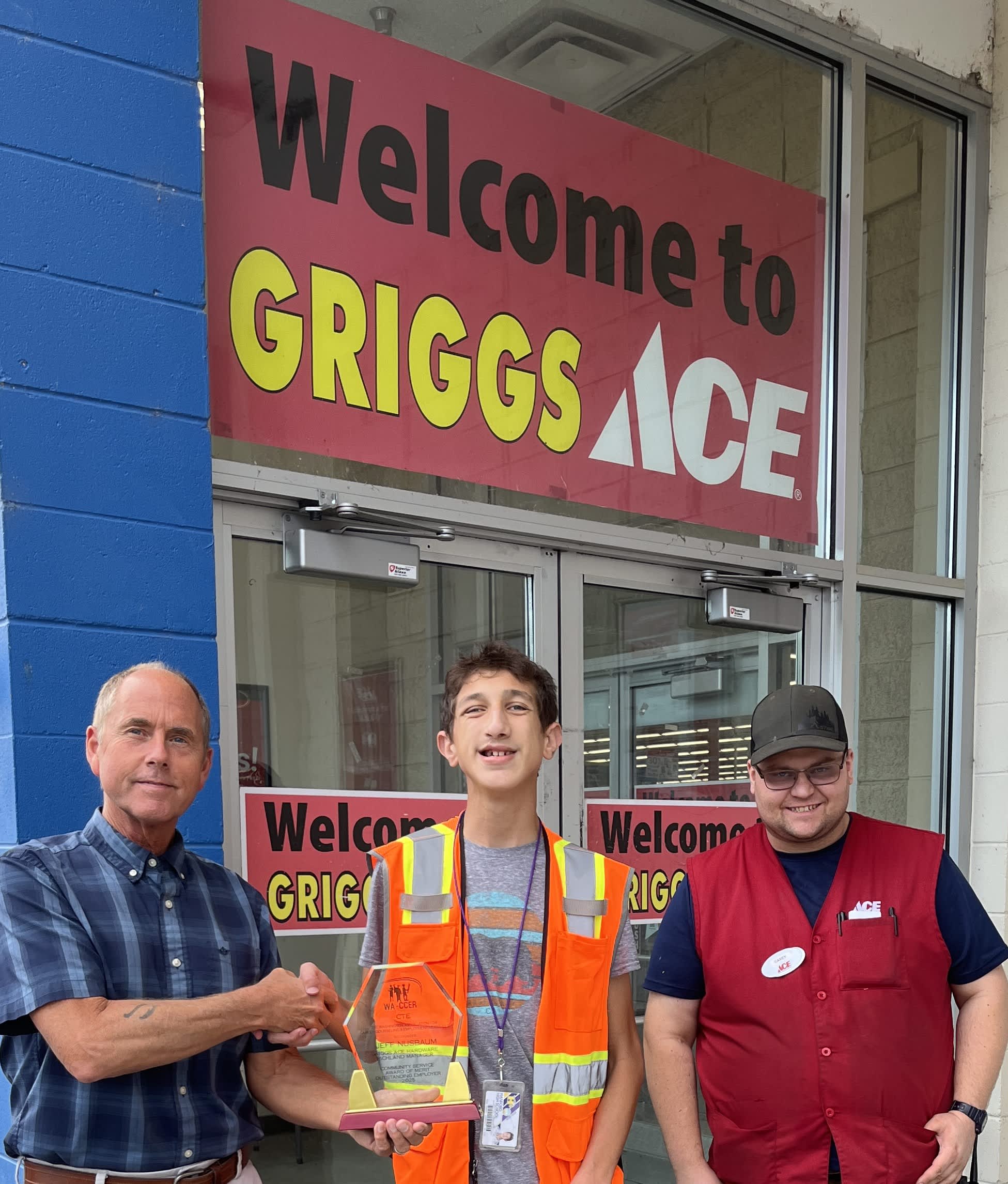 The image shows three men standing in front of a Griggs Ice store, with a "Welcome to Griggs Ice" sign prominently displayed in the background.