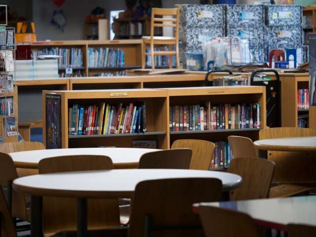 Books on shelves and tables in the library.