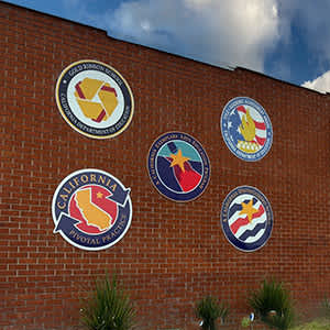 The front of a school site with awards on the front of brick.