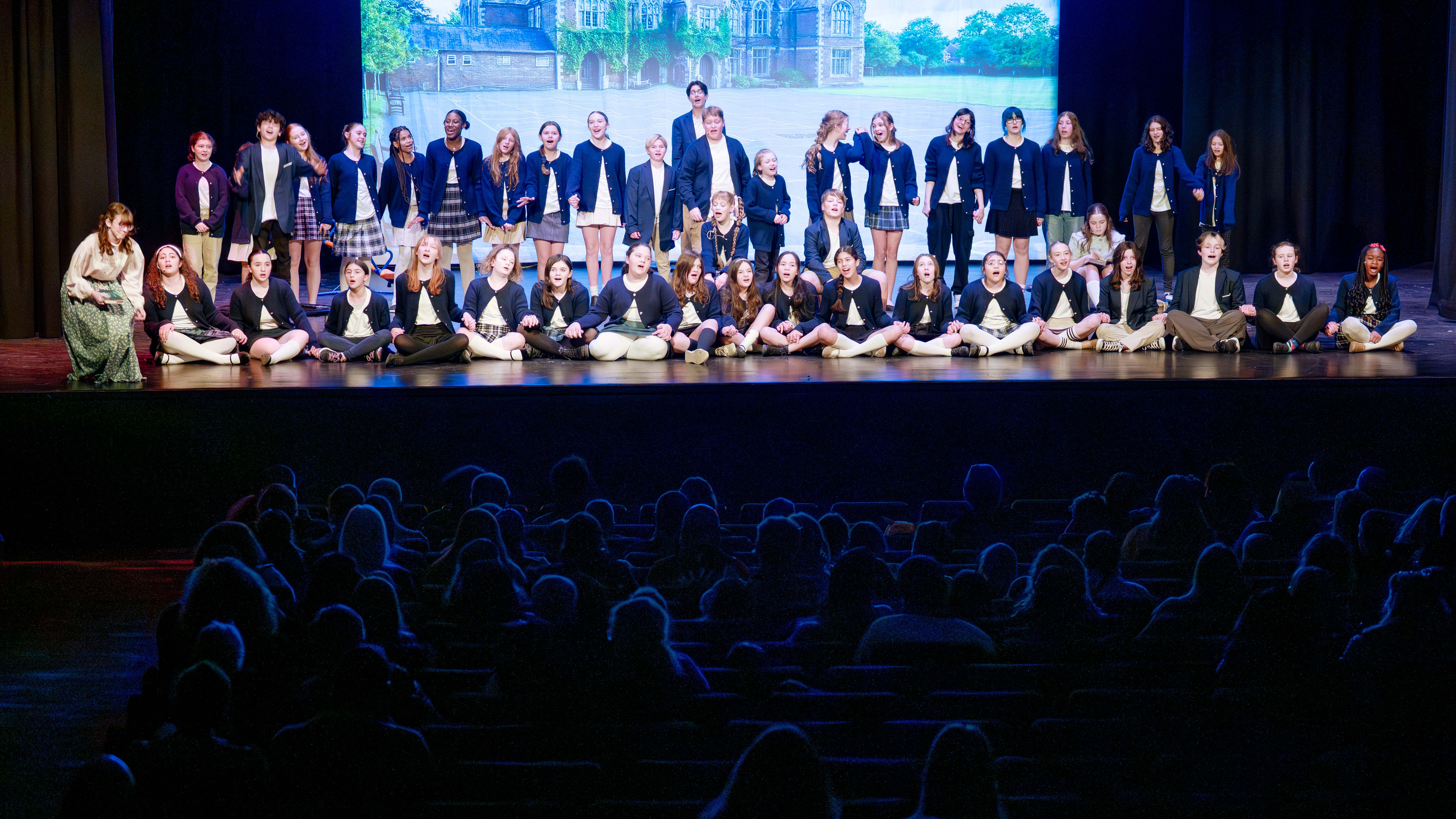 Students in costume, on stage singing