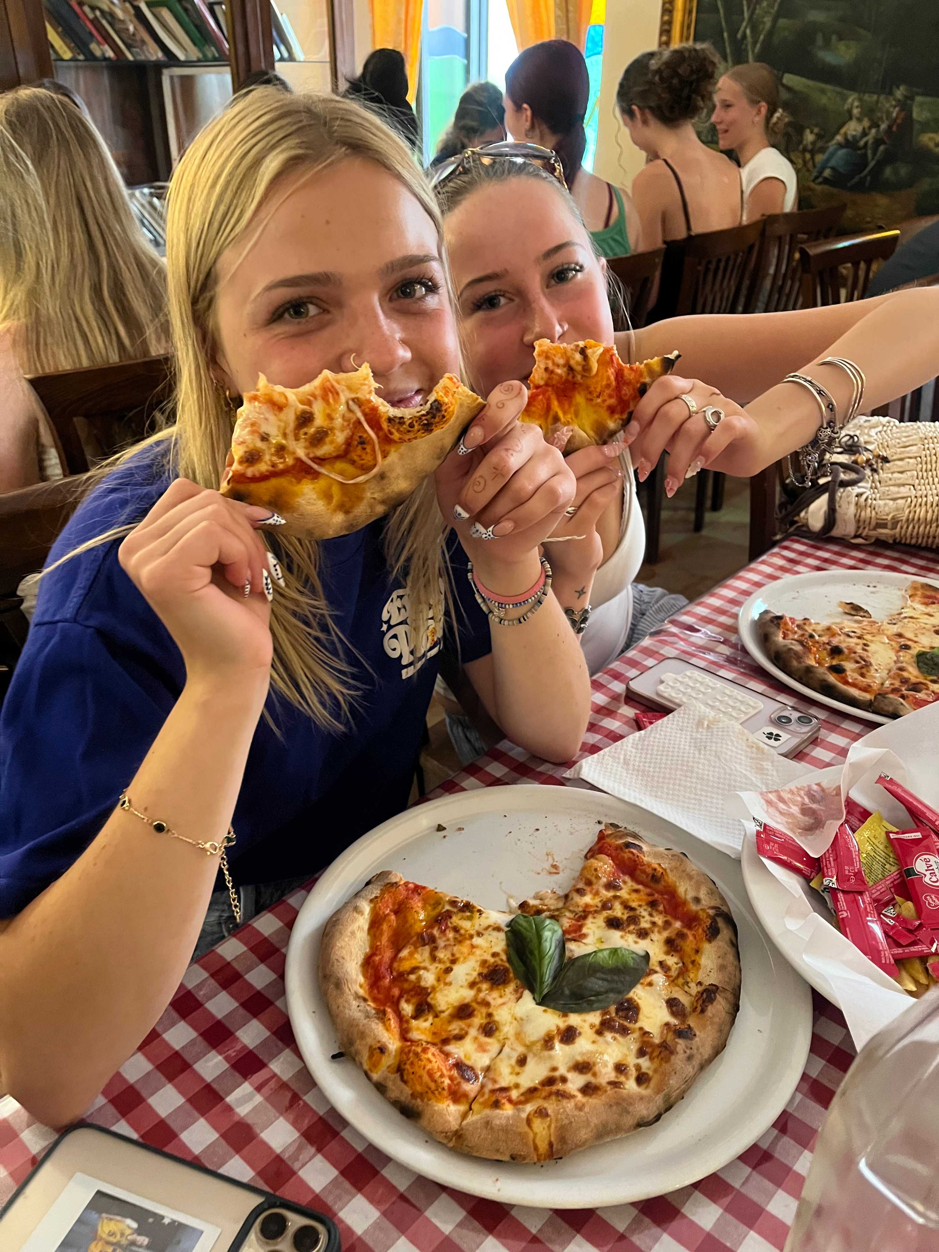 Two CCI students eating pizza together at Allegria