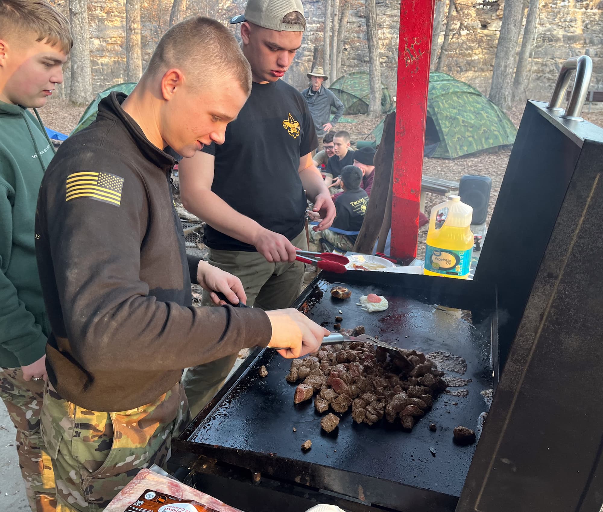 Cadets of Scout Troop 1889 prepare a meal at their campsite.