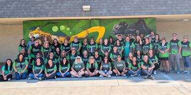 Stacey Middle School staff's group photo in matching green and black shirts.