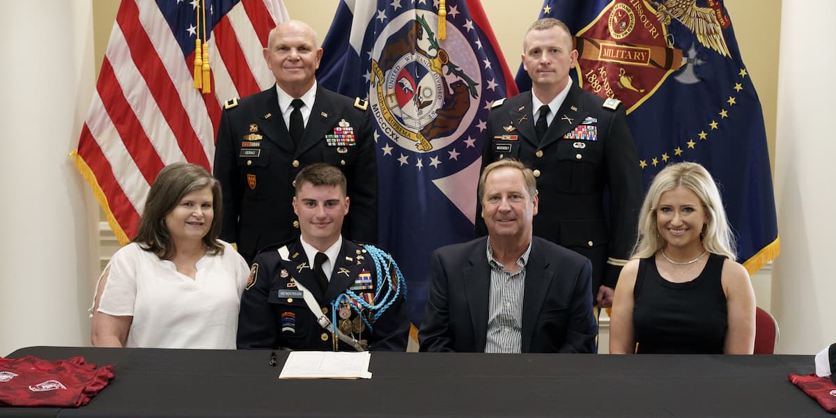 Michael Henderson ’22 with family and ROTC representatives during a signing ceremony.