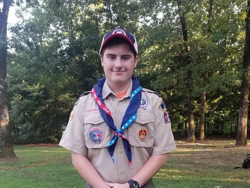 Eagle Scout in uniform smiling outdoors.