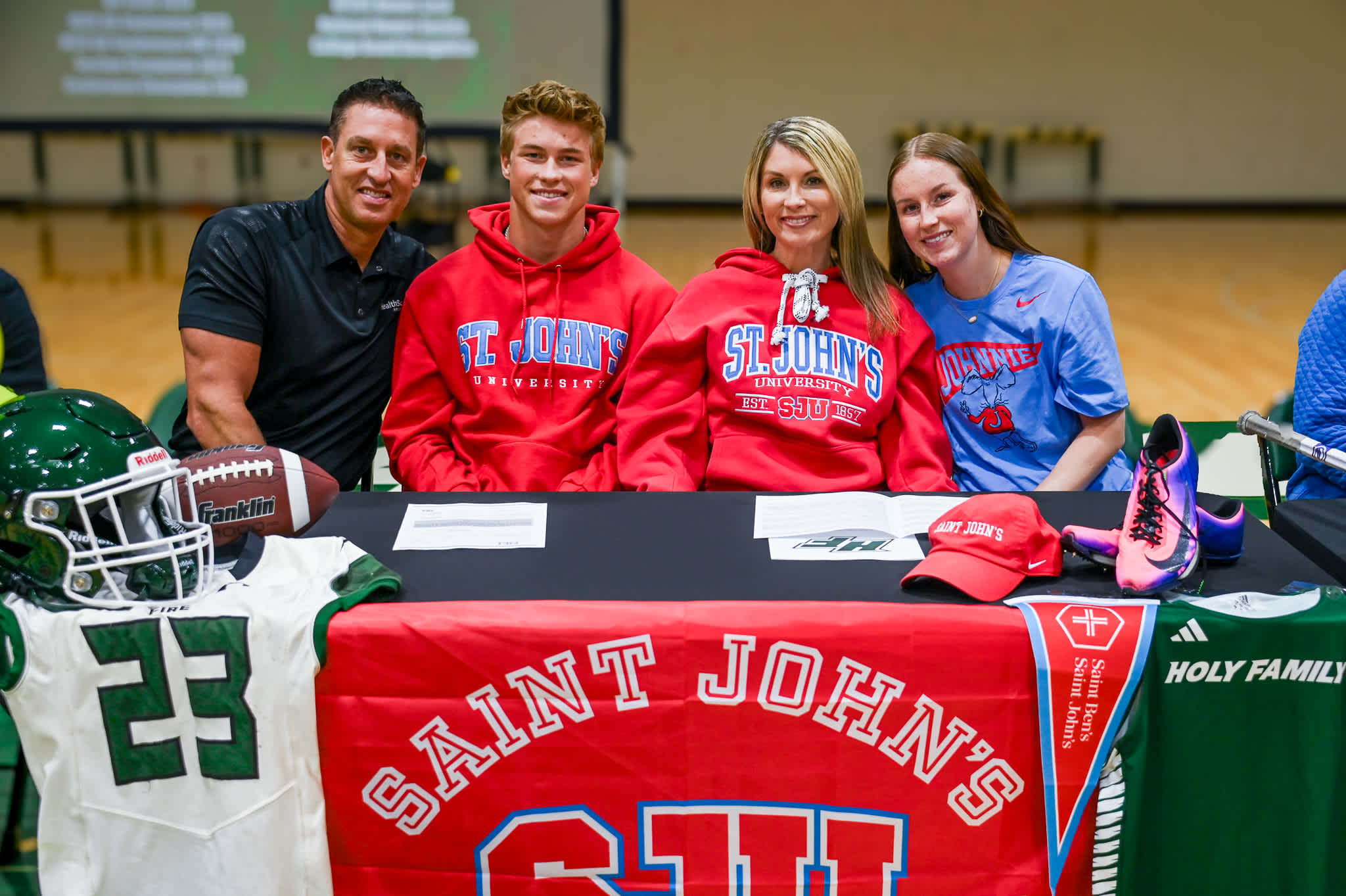 Holy Family senior Breck Neubauer signs to compete in football and track and field at Saint John's University with his family.