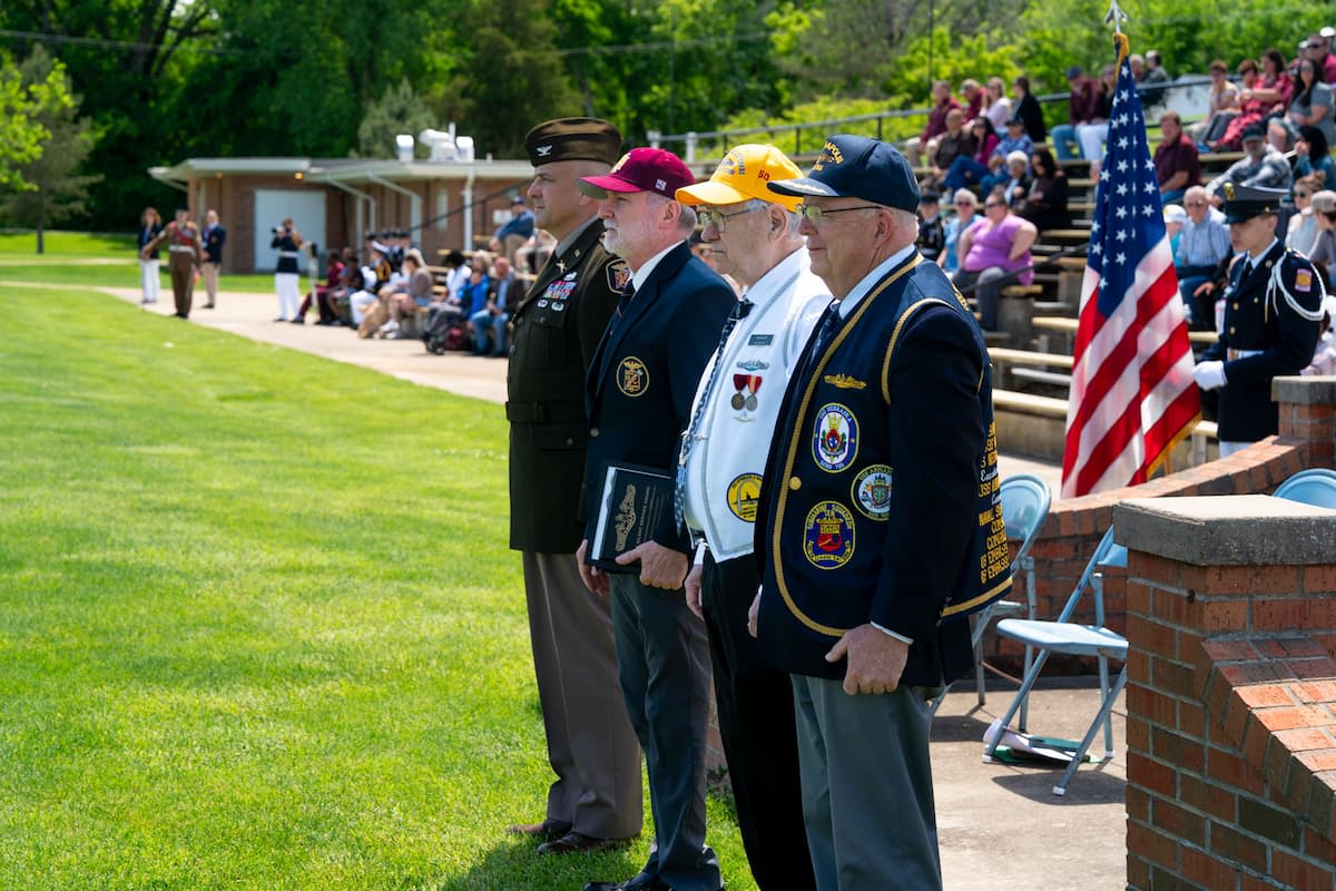 Veterans stand during an awards ceremony as cadets and families gather on the parade field at Missouri Military Academy