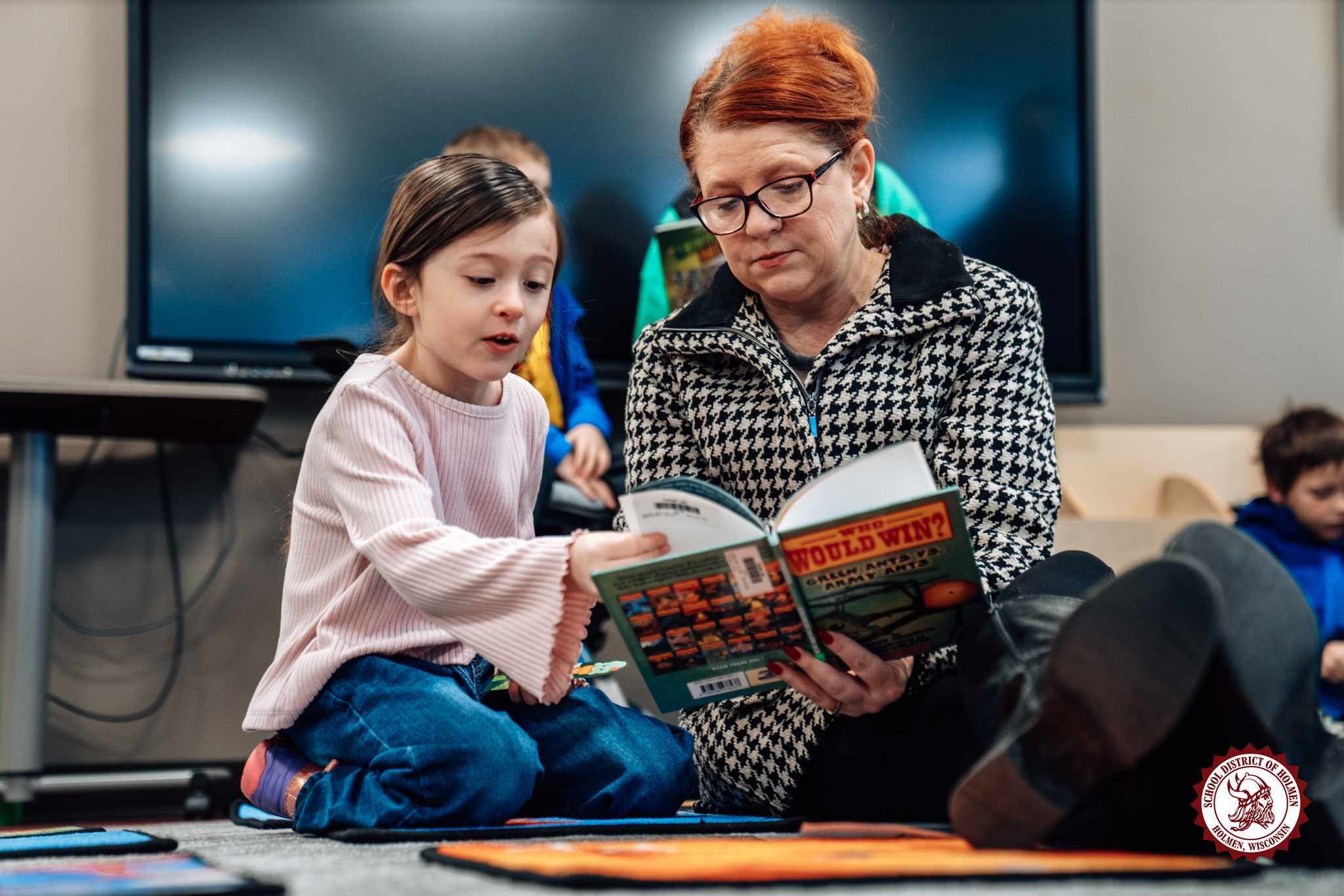 A young student and an adult read a book together during Viking Books and Breakfast.