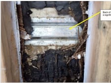 Dark, decayed debris fills the foreground, while a white corrugated surface and a yellow arrow are visible in the background.