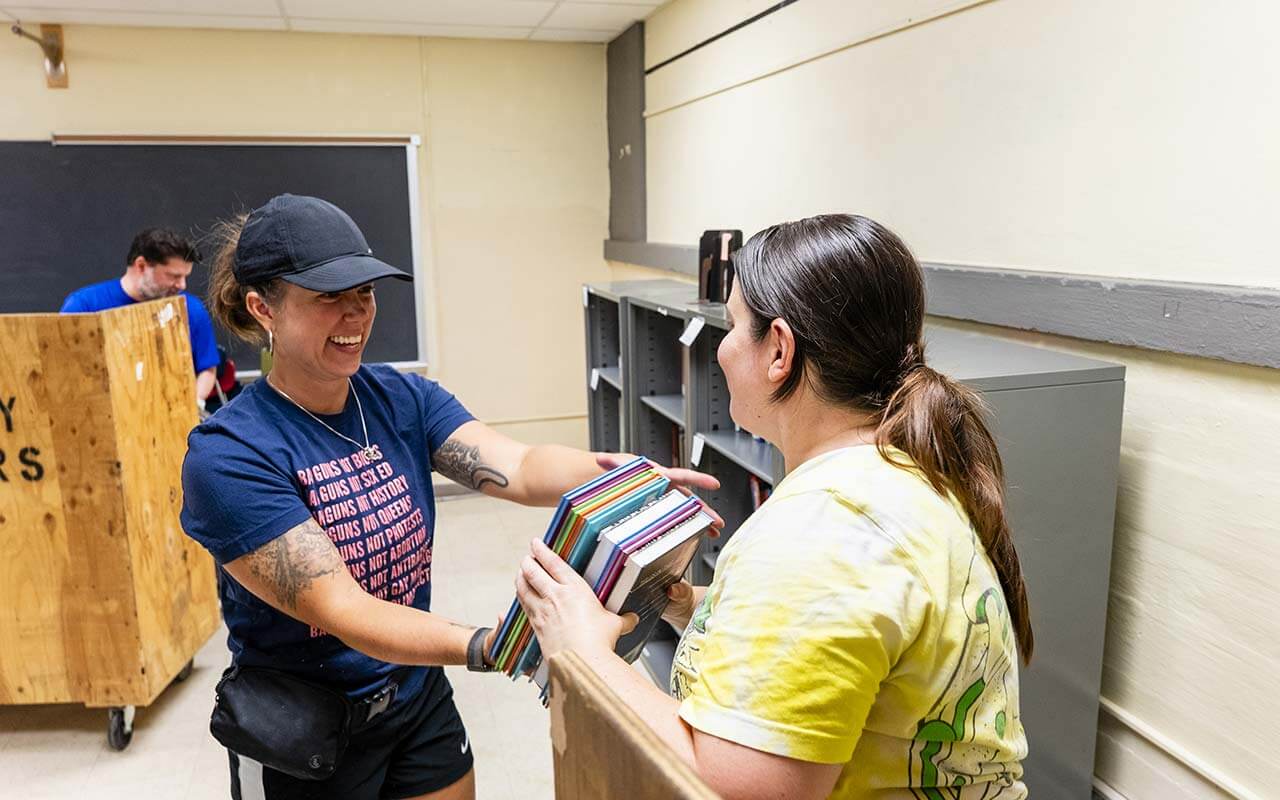Volunteers help move books at Alliance to prepare for the new school year.