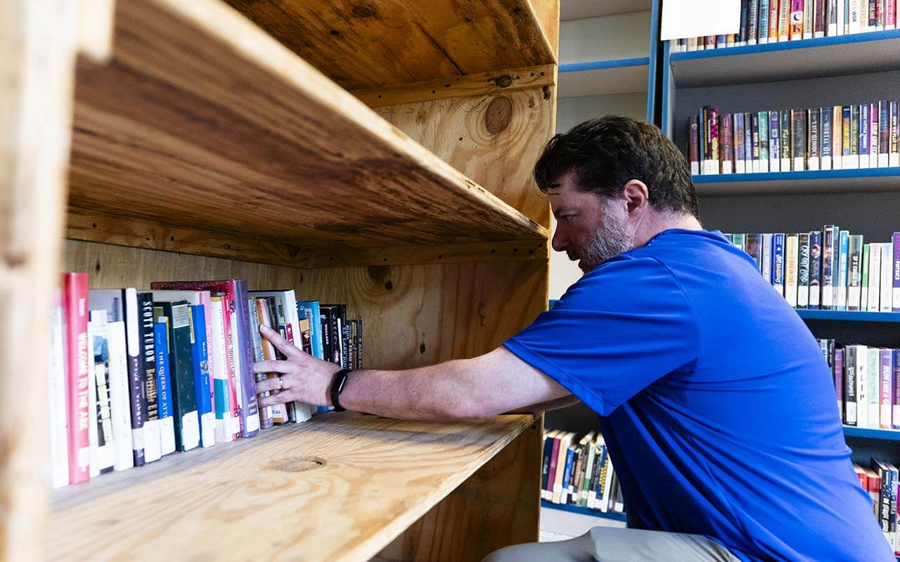 Alliance teacher Chris Gruntzel helps pack up books for the school library's relocation.
