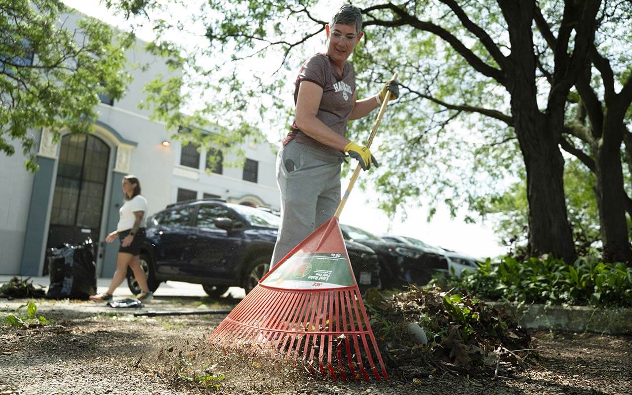Tina Owen-Moore, the founder of the Alliance School of Milwaukee and current MPS board clerk and chief officer of Board Governance, rakes leaves on the school's grounds on the Rebuilding Community work day for volunteers.