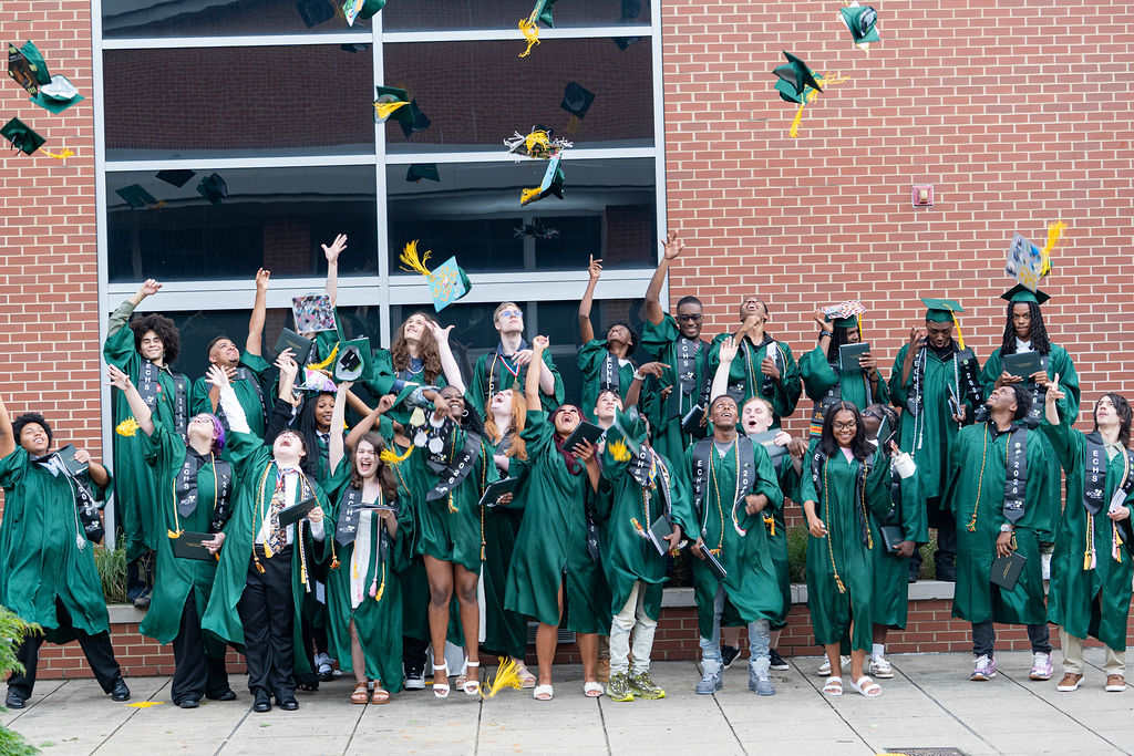 The ECHS Class of 2026 throwing their caps outside the school