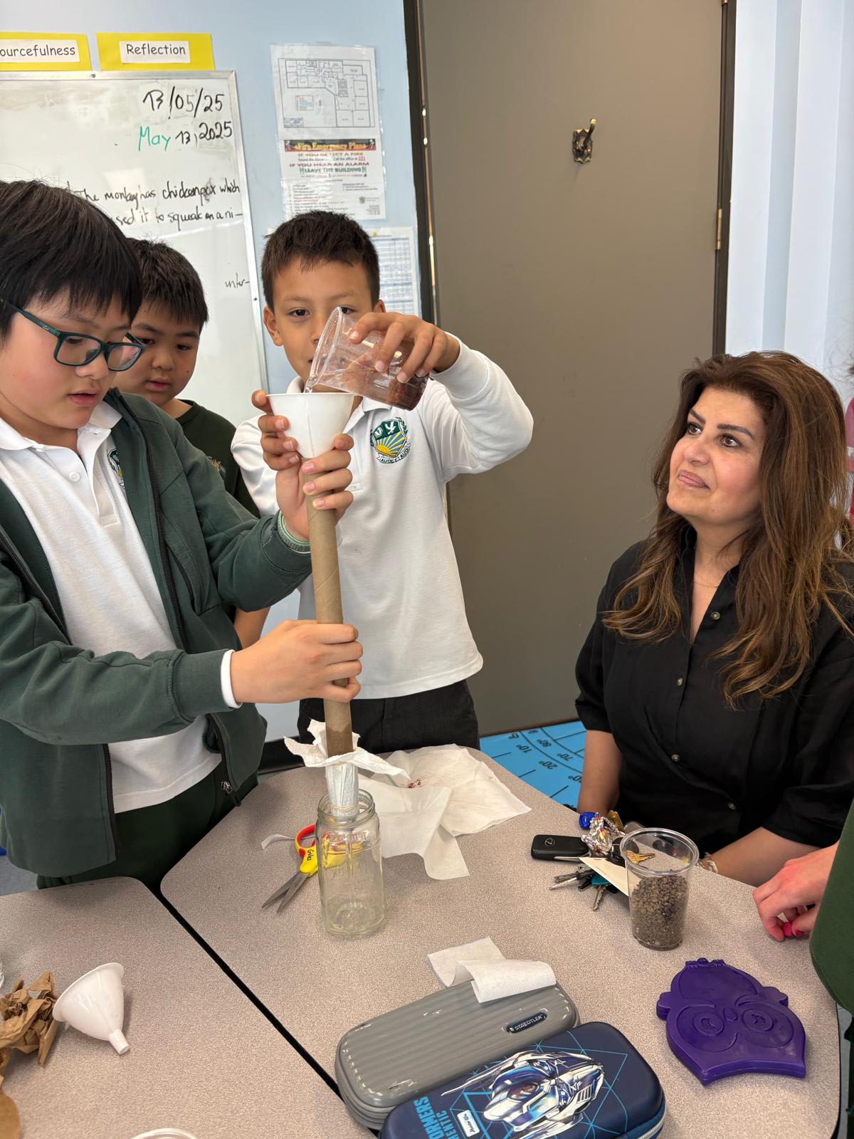 A Giles School teacher observing students during a hands-on science experiment