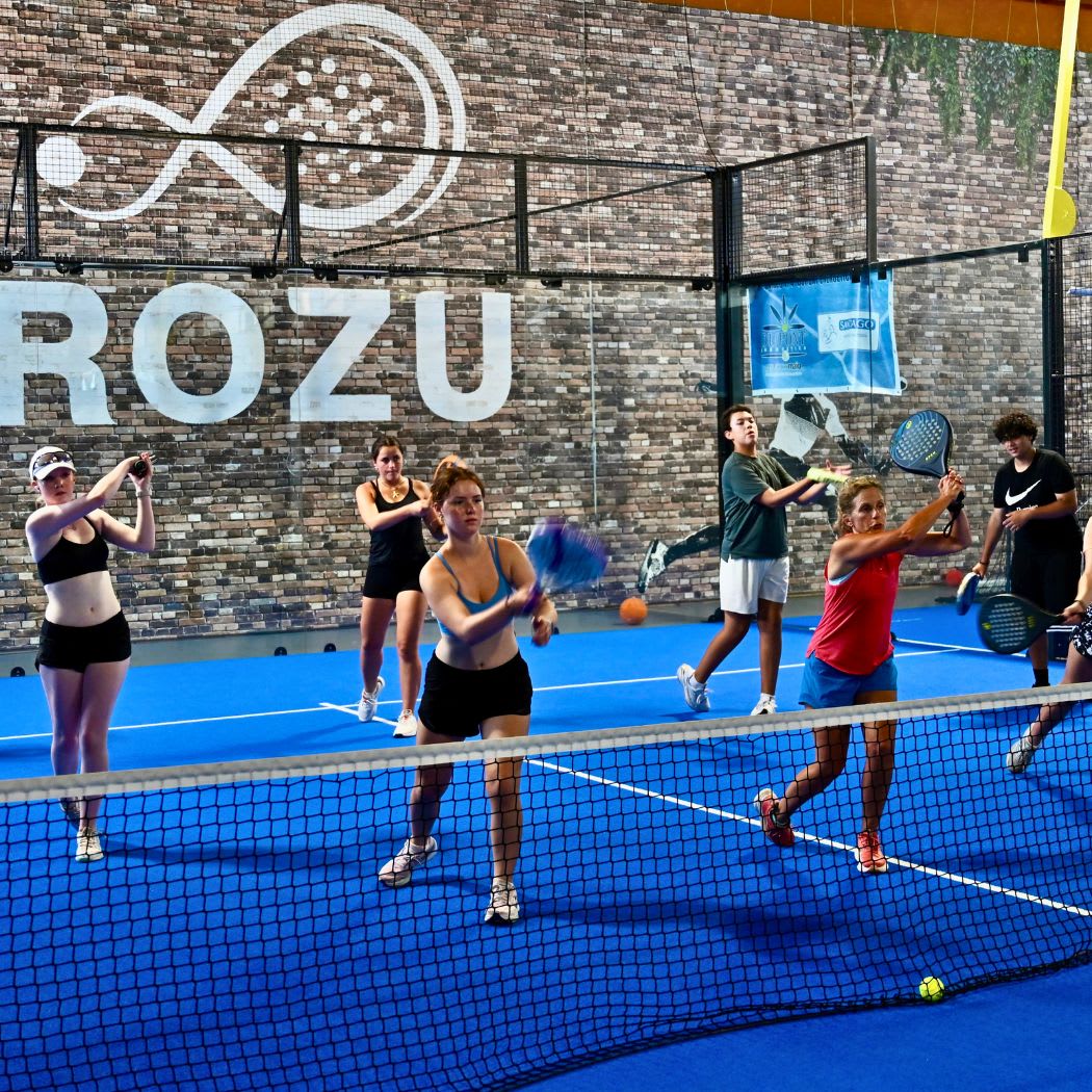 CCI students playing padel together on a blue court