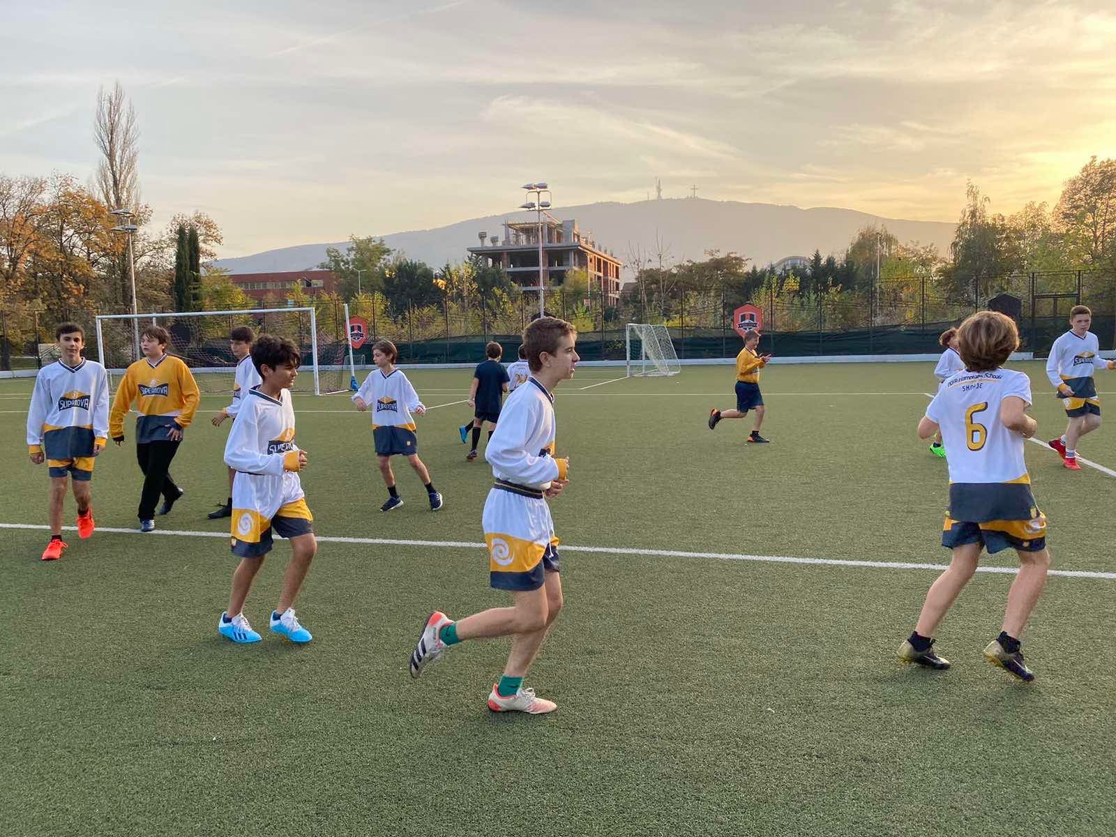 SuperNOVA soccer players on an outdoor field at sunset