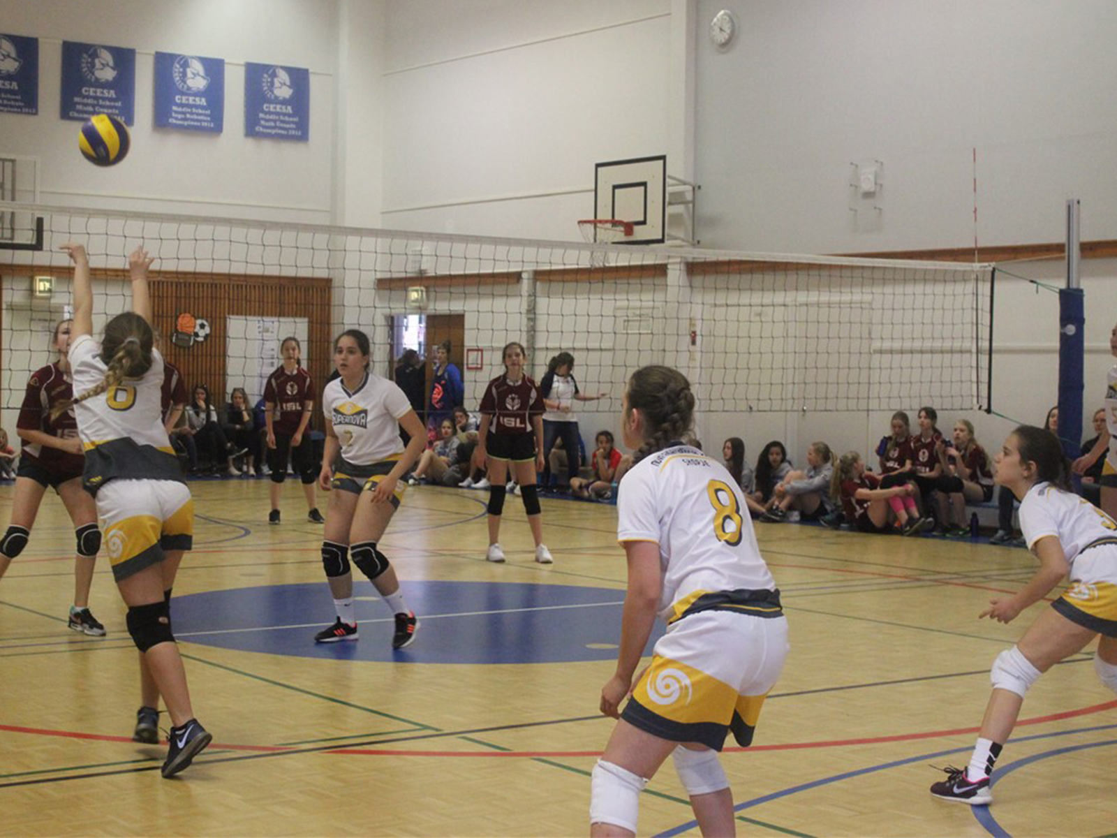 SuperNOVA girls volleyball team playing a match in a sports hall