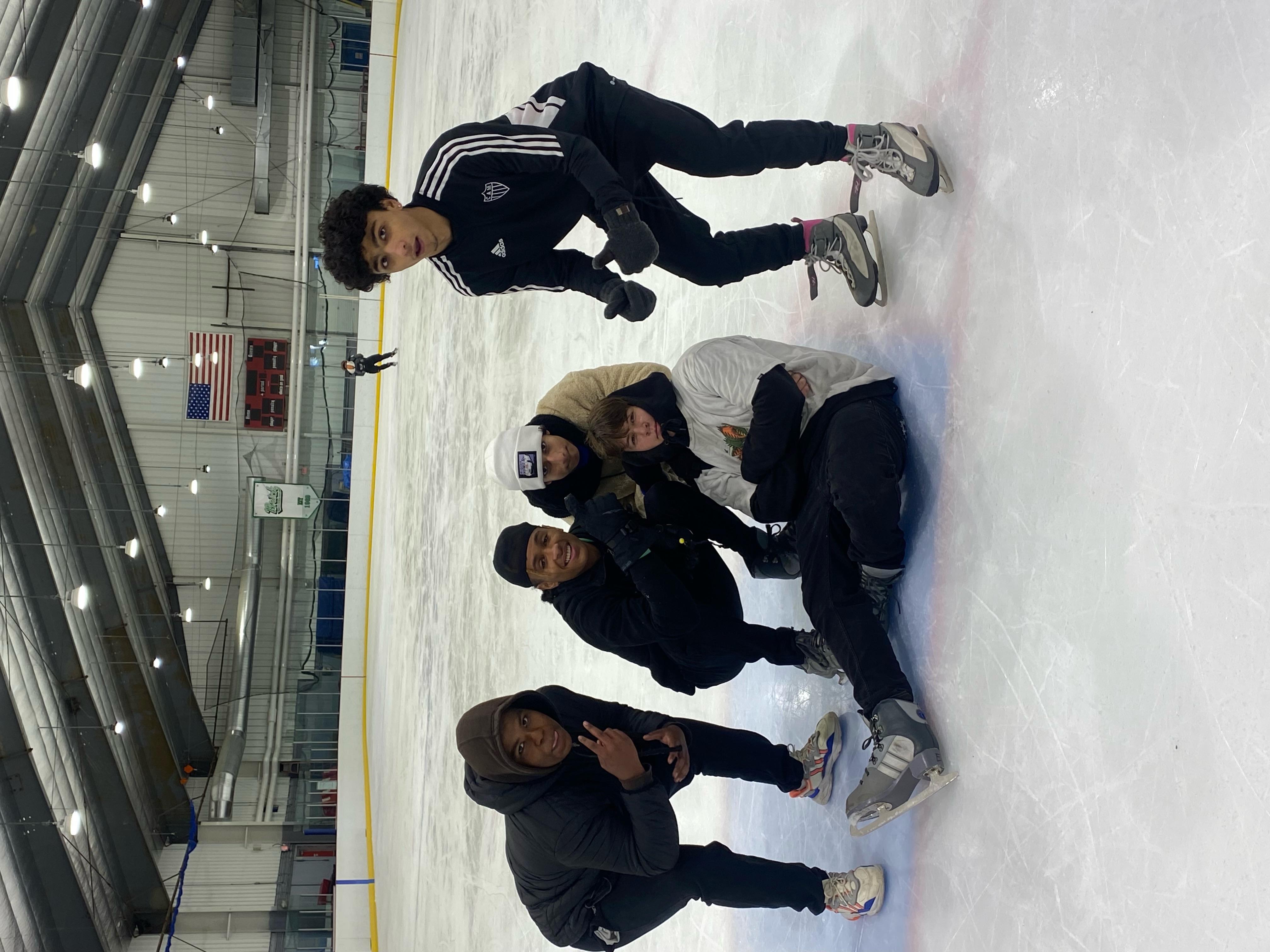 five students ice skating on a class trip