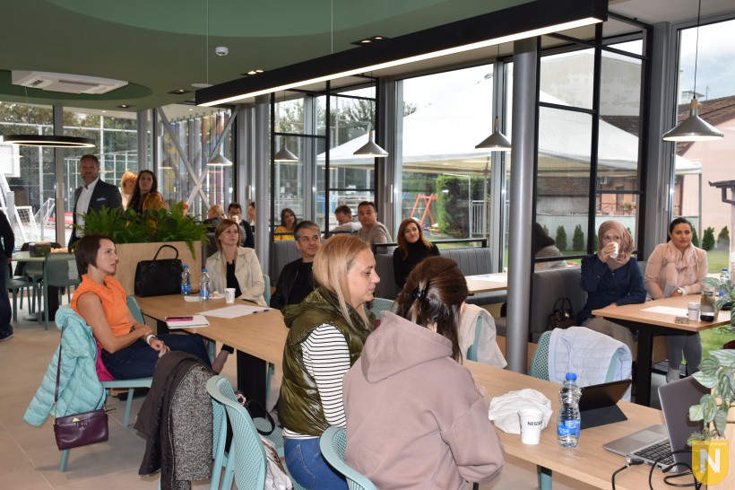 Parents and faculty at tables in the bright cafeteria during the coffee morning